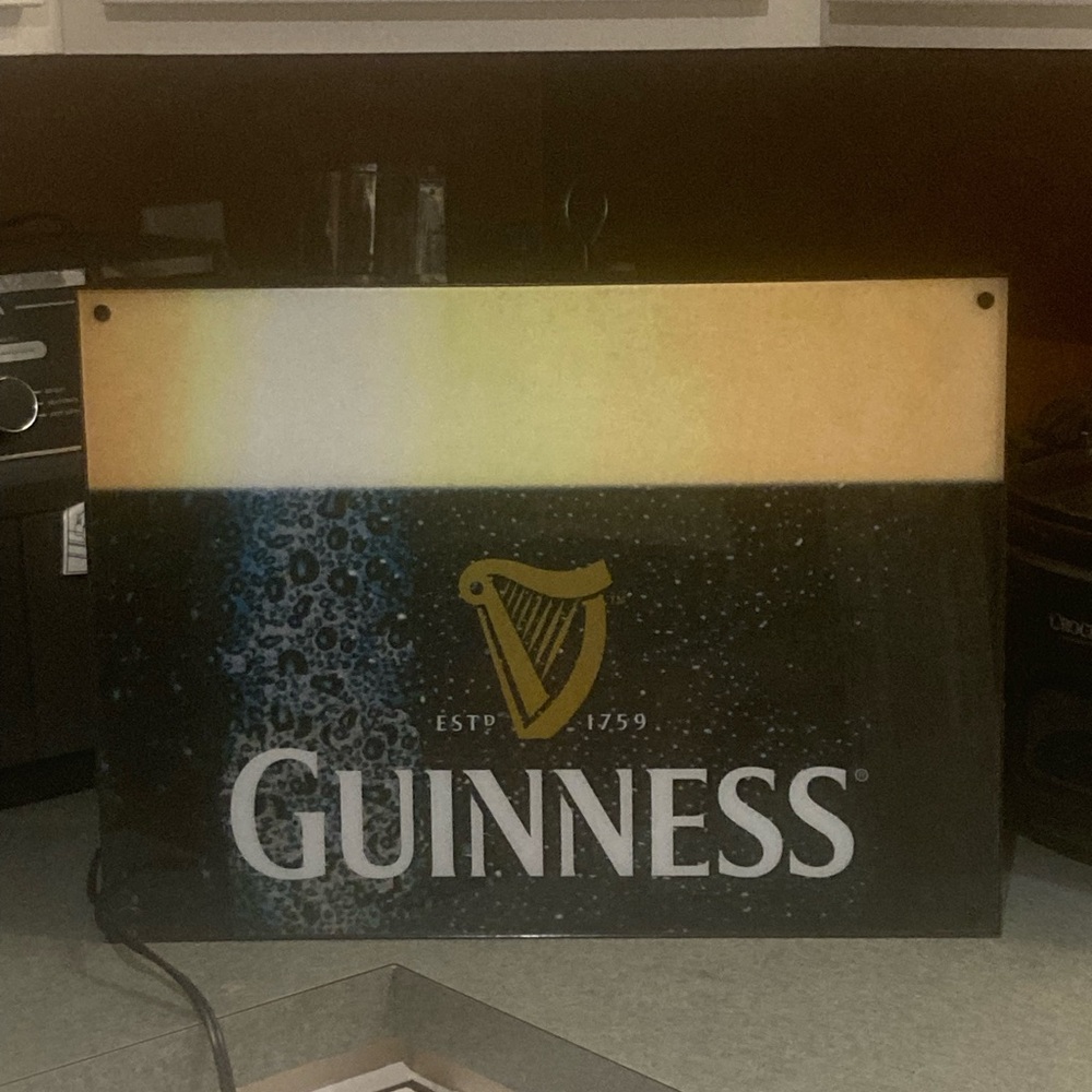 Guinness Sign with Gold Harp on Teal-Blue Backdrop